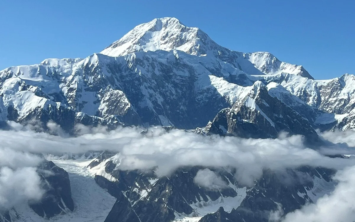 A long panorama of the Alaska Range from the air, ridge after ridge of snow and rock running to the horizon